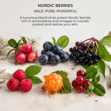 Nordic berries blend featuring fresh berries including blueberries, red cranberries, black elderberries, raspberries, and an orange berry, arranged on a light marble surface with text at the top reading 'NORDIC BERRIES WILD. PURE. POWERFUL.