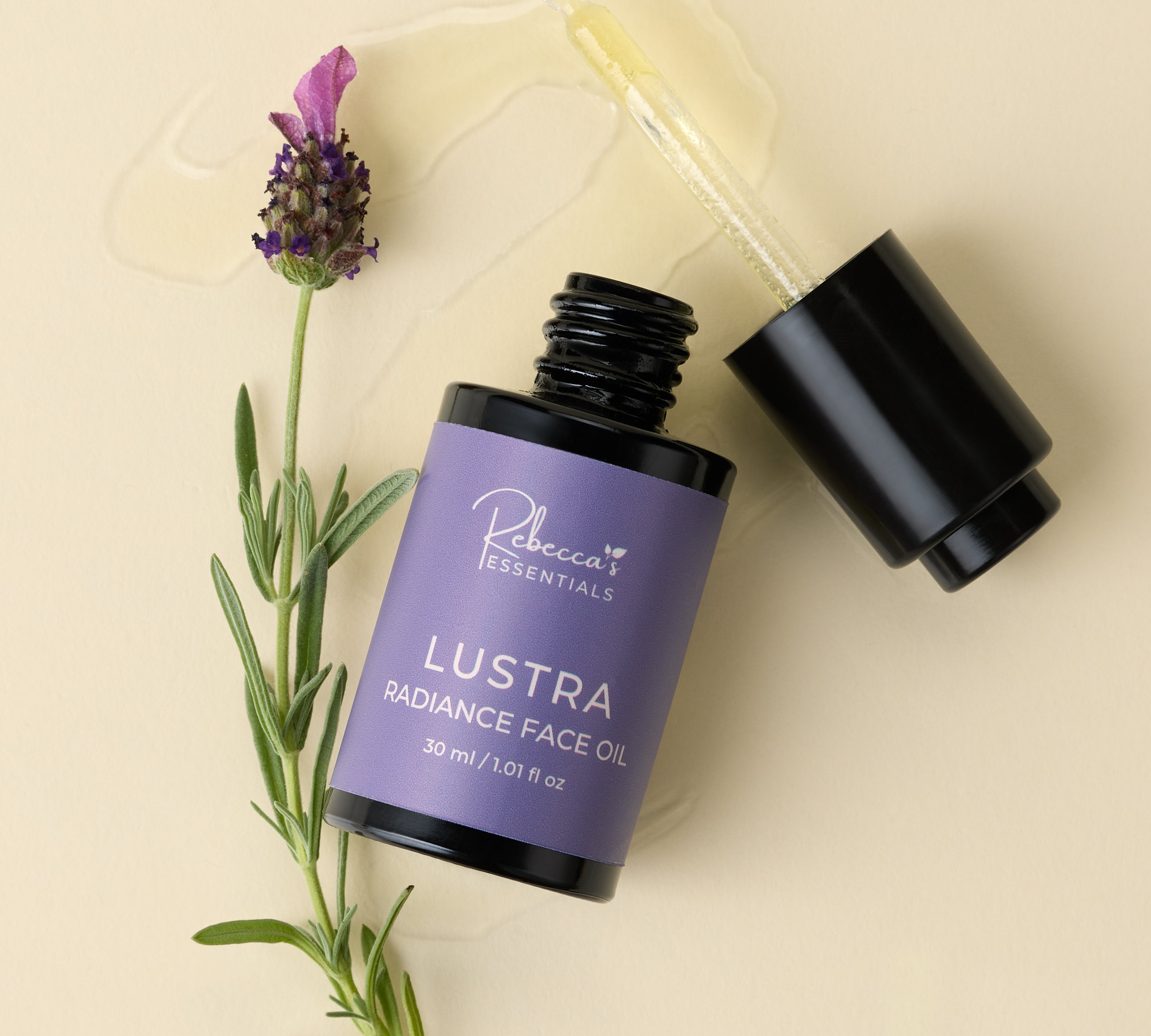 Lustria Radiance Face Oil bottle with push button pipette showing oil along with lavender plant on beige background