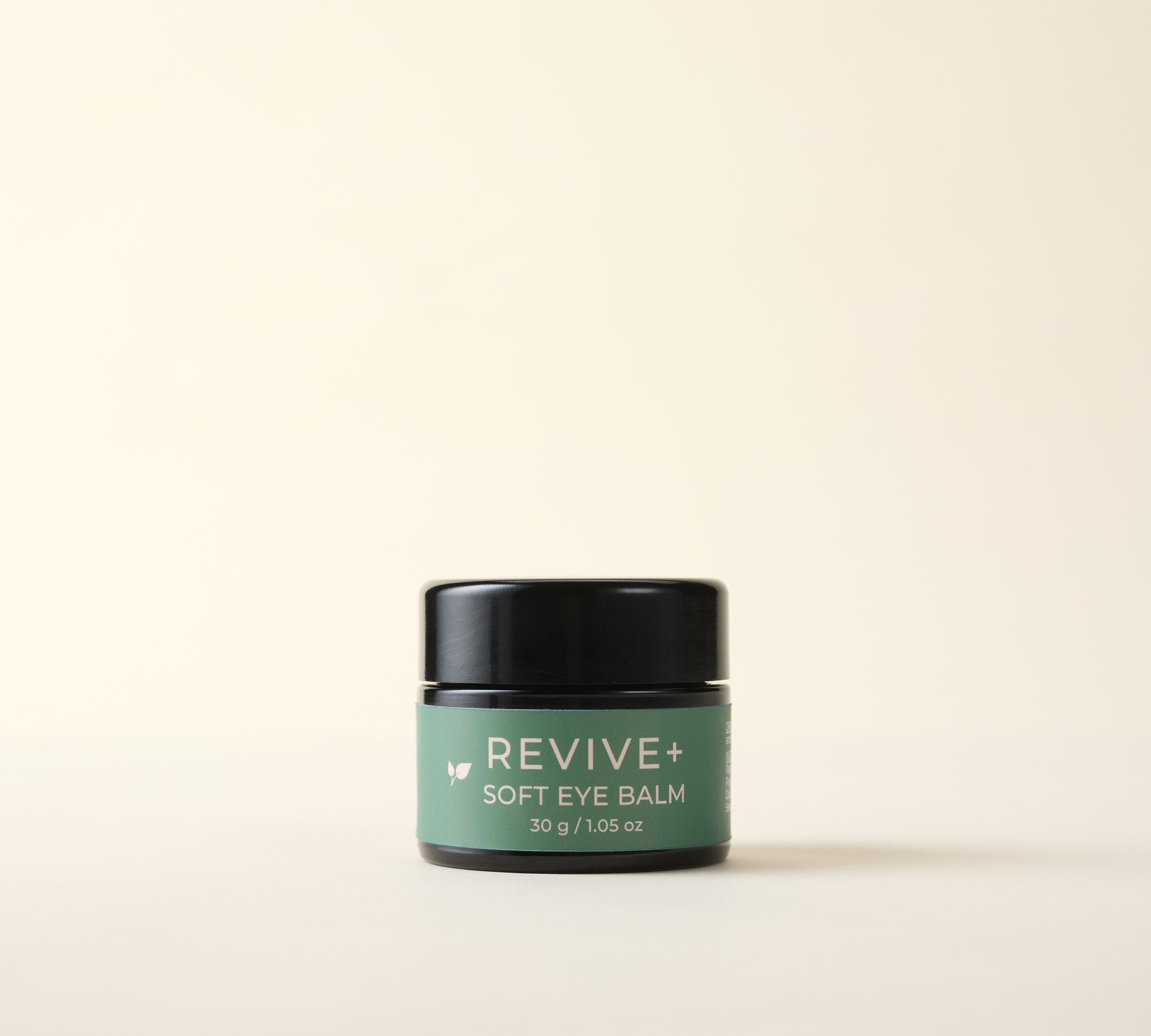 Jar of Revive+ Soft Eye Balm on a beige background.